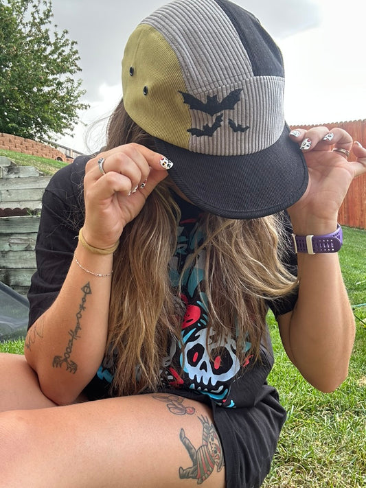 Person wearing a cap with a bats design outdoors
